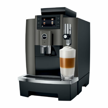 Machine à café automatique Jura W8 vue de face, préparant un latte macchiato avec une couche de mousse de lait dense dans un verre transparent.