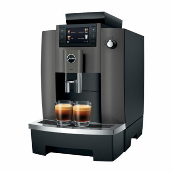 Machine à café automatique JURA W4 noire avec deux tasses de café placées sur le plateau, affichant un écran tactile avec des options de boissons.